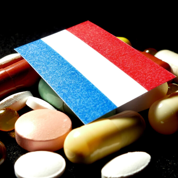 Voor Nederland geldt dit extra scherp. Nederland staat op de Amerikaanse referentielijst voor GLOBE, GUARD en GENEROUS: als Nederlandse prijsinformatie wordt gebruikt, kan een Nederlandse prijs onderdeel worden van de Amerikaanse prijsberekening. Een lage Nederlandse prijs kan zo in de Verenigde Staten als argument worden gebruikt voor een lagere Amerikaanse vergoeding — een prijsafspraak die in Nederland past bij het Nederlandse zorgbudget, kan daarmee gevolgen krijgen in een veel grotere markt. Nederland heeft een relatief sterk beleid voor kostenbeheersing: volgens cijfers van de Nederlandse Zorgautoriteit dalen de uitgaven per patiënt aan innovatieve geneesmiddelen, terwijl het aantal patiënten stijgt. Vanuit het oogpunt van betaalbaarheid is dat positief, maar het huidige beleid is niet ingericht op het risico dat een lage Nederlandse prijs internationaal doorwerkt. Nederland vertegenwoordigt voor een gemiddeld geneesmiddelenbedrijf ongeveer 1% van de wereldwijde afzetmarkt — te klein om zelfstandig veel gewicht in de schaal te leggen tegenover een fabrikant die tegelijk naar de veel grotere Amerikaanse markt kijkt.