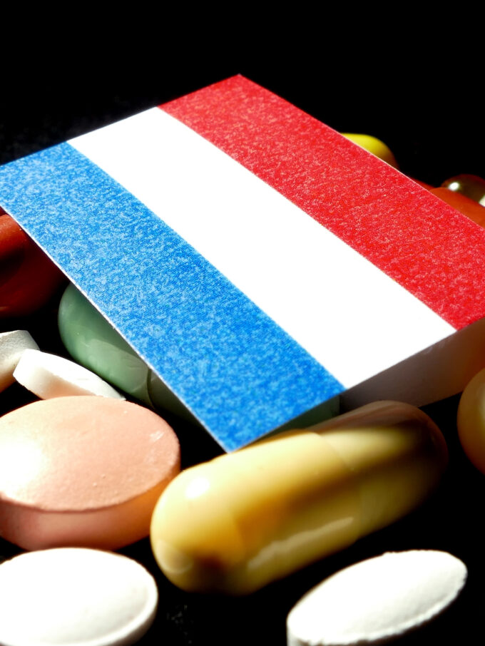 Voor Nederland geldt dit extra scherp. Nederland staat op de Amerikaanse referentielijst voor GLOBE, GUARD en GENEROUS: als Nederlandse prijsinformatie wordt gebruikt, kan een Nederlandse prijs onderdeel worden van de Amerikaanse prijsberekening. Een lage Nederlandse prijs kan zo in de Verenigde Staten als argument worden gebruikt voor een lagere Amerikaanse vergoeding — een prijsafspraak die in Nederland past bij het Nederlandse zorgbudget, kan daarmee gevolgen krijgen in een veel grotere markt. Nederland heeft een relatief sterk beleid voor kostenbeheersing: volgens cijfers van de Nederlandse Zorgautoriteit dalen de uitgaven per patiënt aan innovatieve geneesmiddelen, terwijl het aantal patiënten stijgt. Vanuit het oogpunt van betaalbaarheid is dat positief, maar het huidige beleid is niet ingericht op het risico dat een lage Nederlandse prijs internationaal doorwerkt. Nederland vertegenwoordigt voor een gemiddeld geneesmiddelenbedrijf ongeveer 1% van de wereldwijde afzetmarkt — te klein om zelfstandig veel gewicht in de schaal te leggen tegenover een fabrikant die tegelijk naar de veel grotere Amerikaanse markt kijkt.