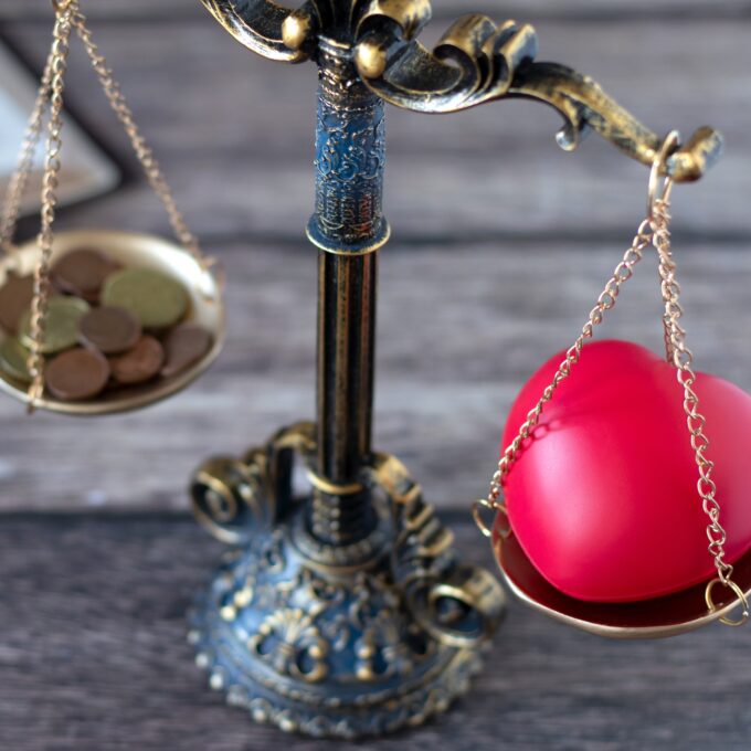 weegschaal die balanceert tussen een hart en geld